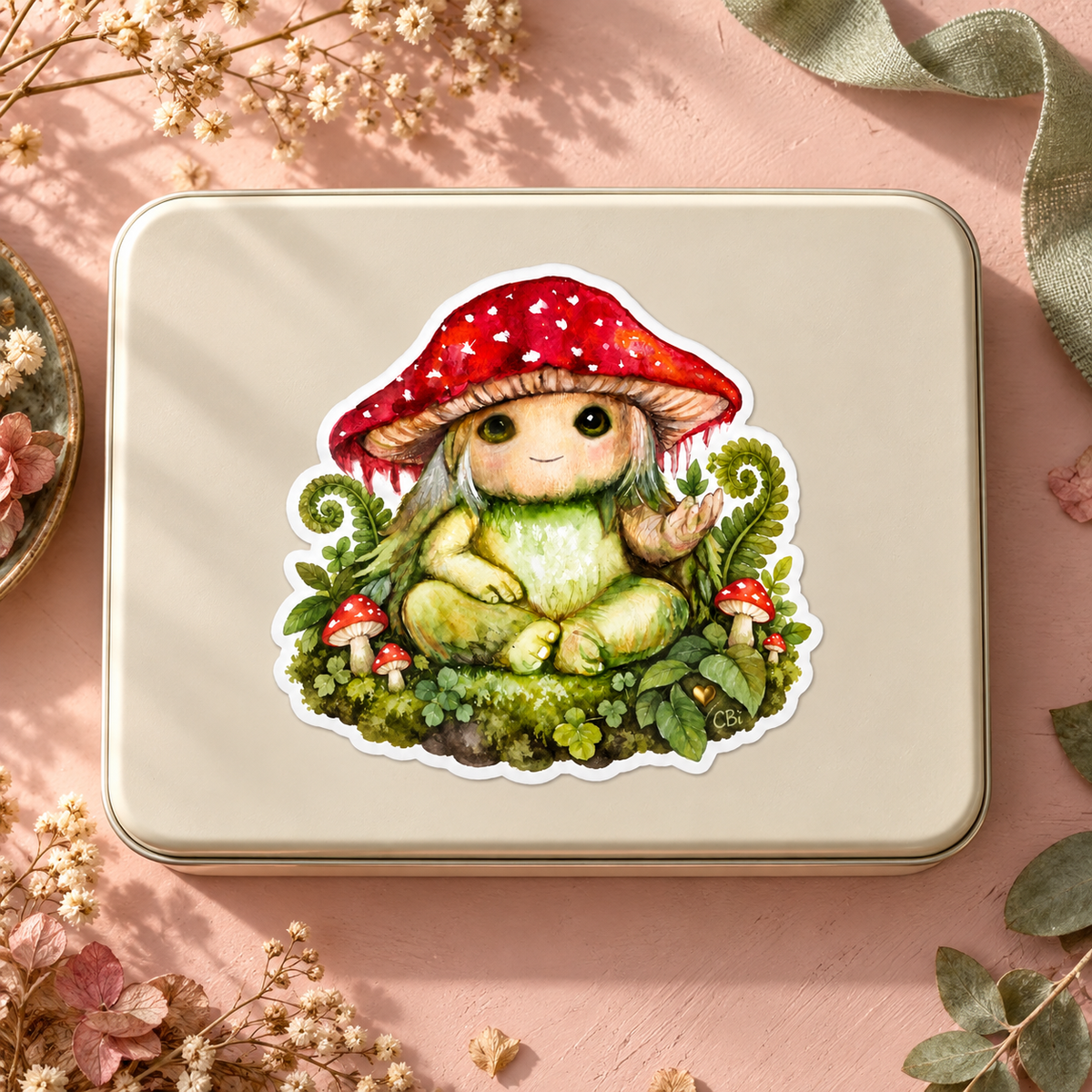 Pippin’s Little Forest Patch sticker on a cream stationery tin in a styled overhead view, with its gold heart detail.