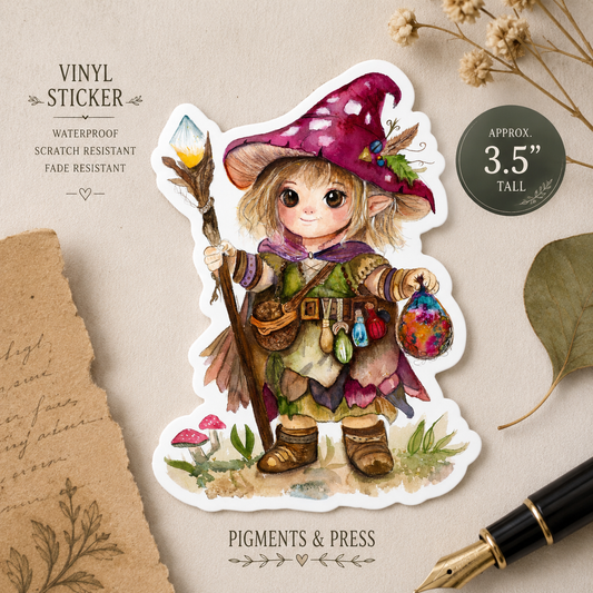 Cottage Witch white vinyl die-cut sticker approximately 3.5 inches tall, shown on a warm neutral background with dried flowers and a fountain pen