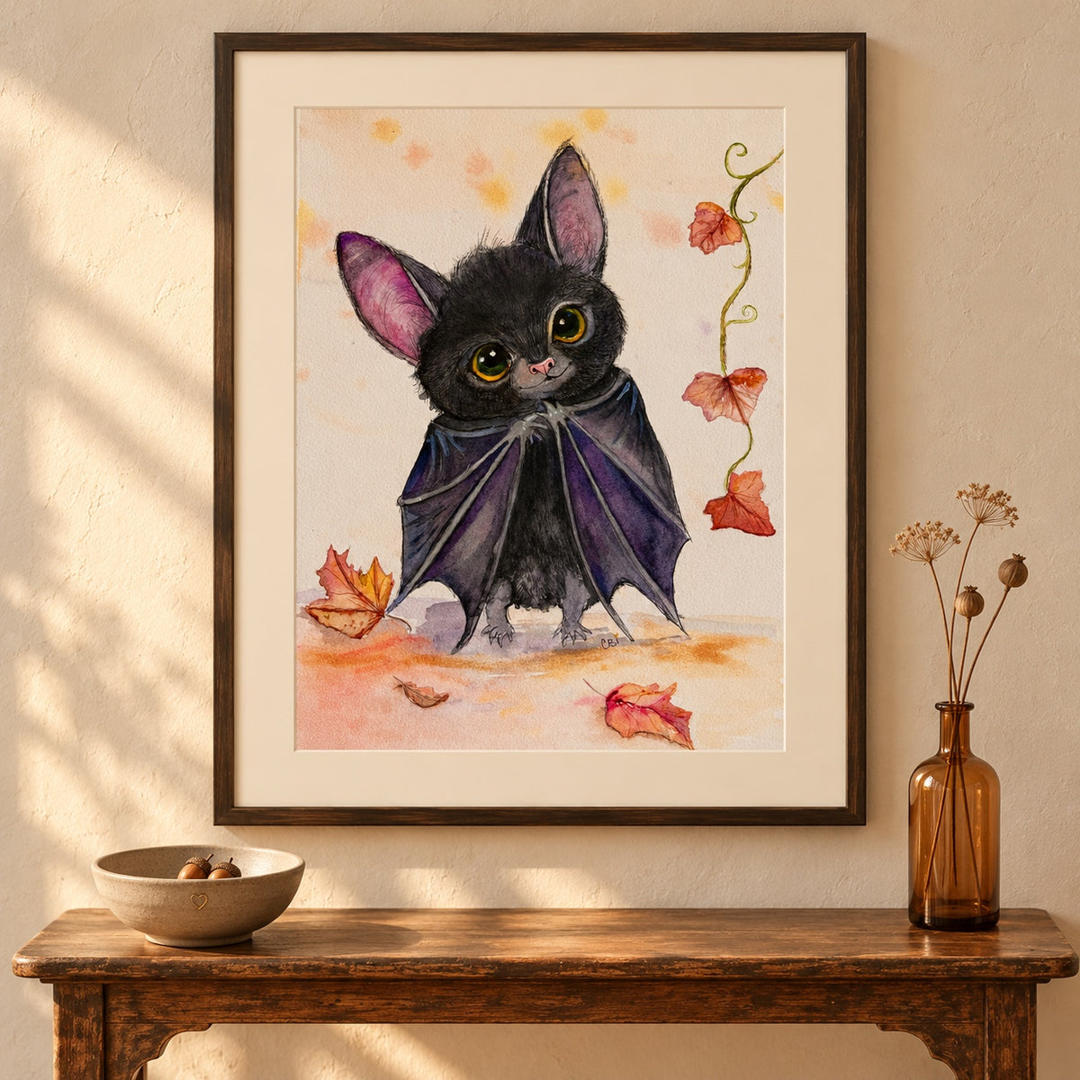Batinsky print in a dark frame above a wooden console with an acorn bowl and amber vase.