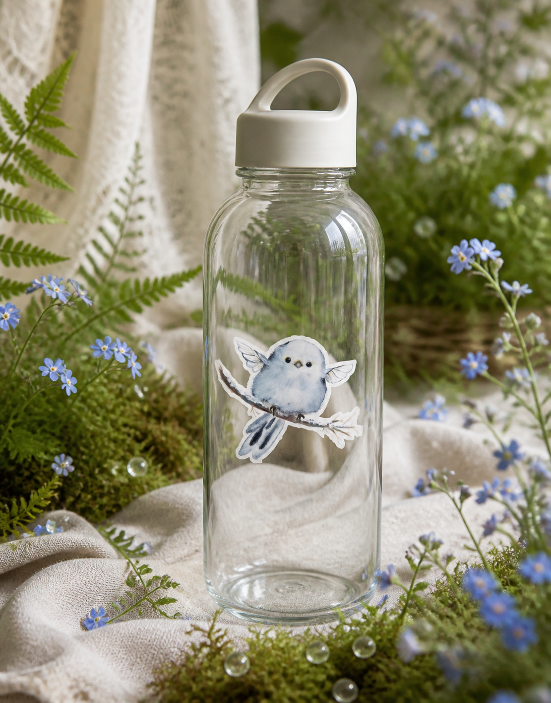 Blue Fairy Nestling vinyl sticker on a clear reusable water bottle with woodland flowers