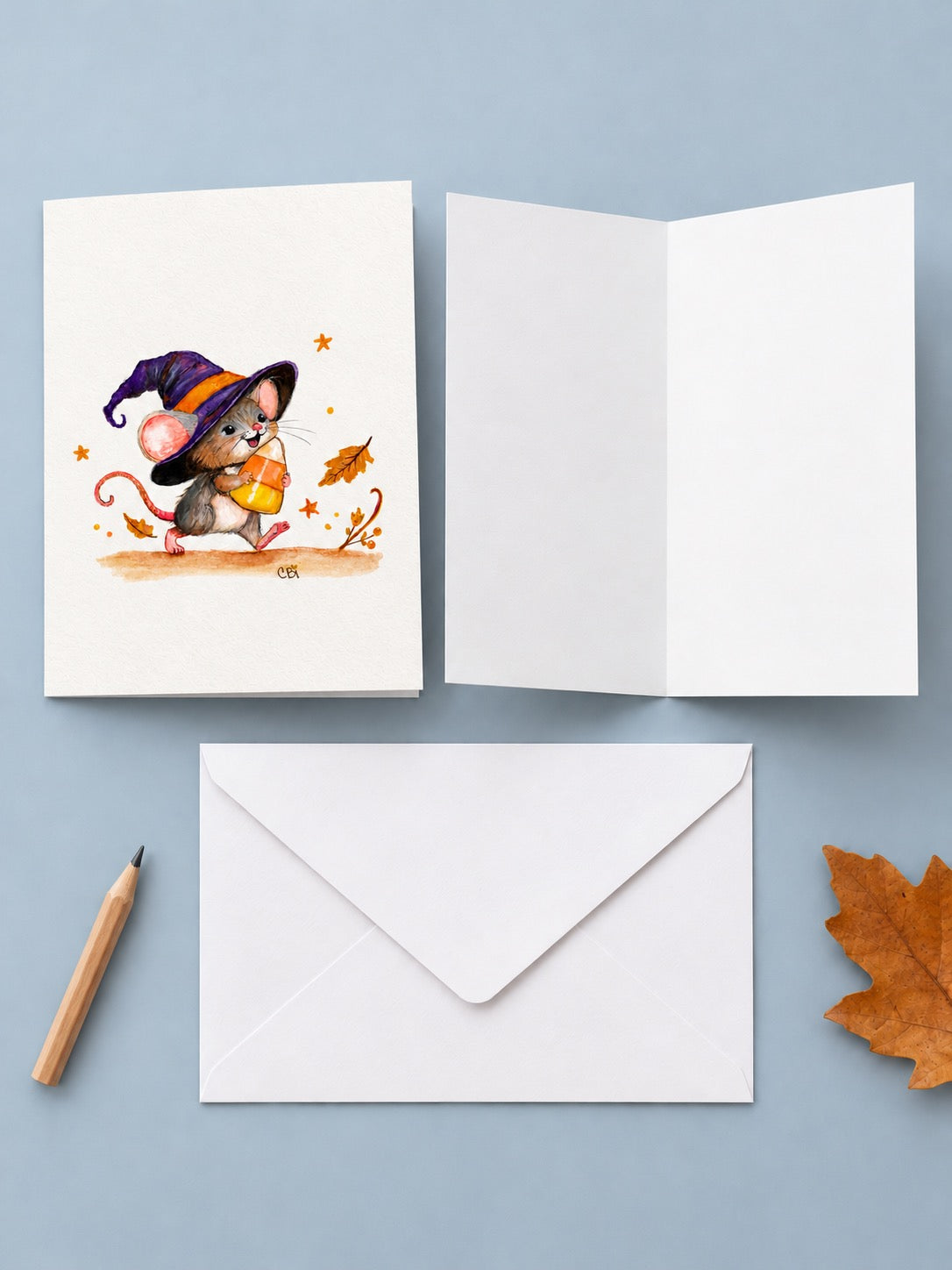 Front and blank interior views of the Candy Corn Mischief greeting card with one white envelope.