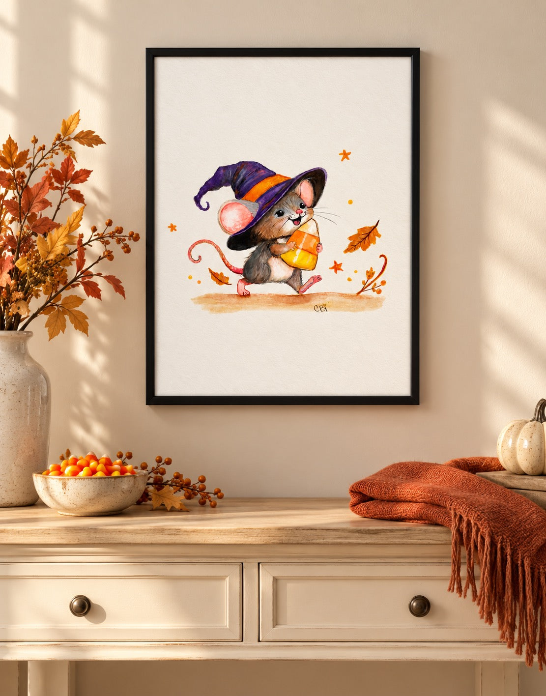 Candy Corn Mischief print framed above an entryway console with a candy bowl and rust scarf.