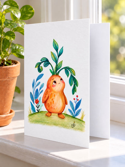 Figment greeting card with artwork inset within white margins and a simple left-side fold, on a windowsill beside a potted plant.