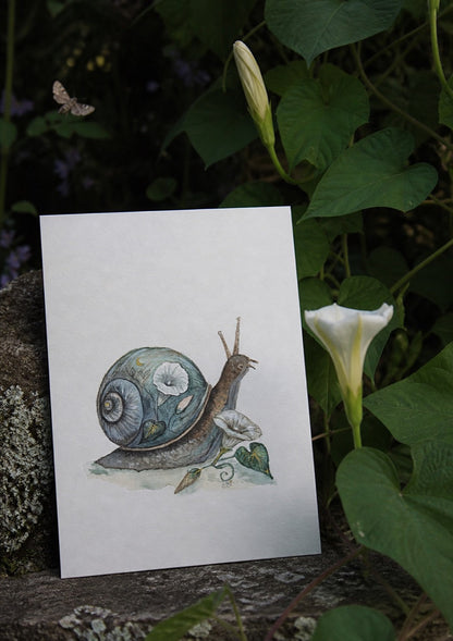 Moon greeting card beside an opening moonflower at night