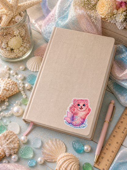 Pearl Mermaid Bear vinyl sticker on a full-size journal with seashells and sea glass