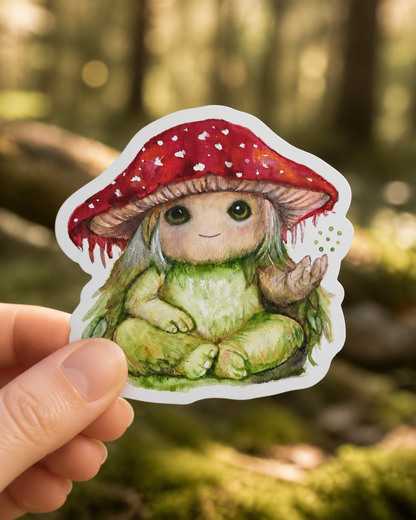Pippin the Mycora vinyl sticker held in woodland